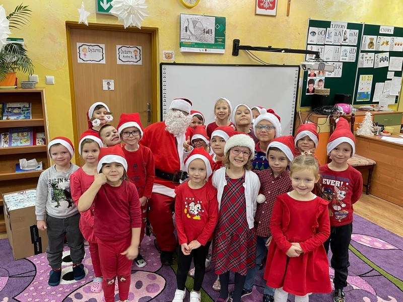 Dzieci stoją przytulone do Świętego Mikołaja 