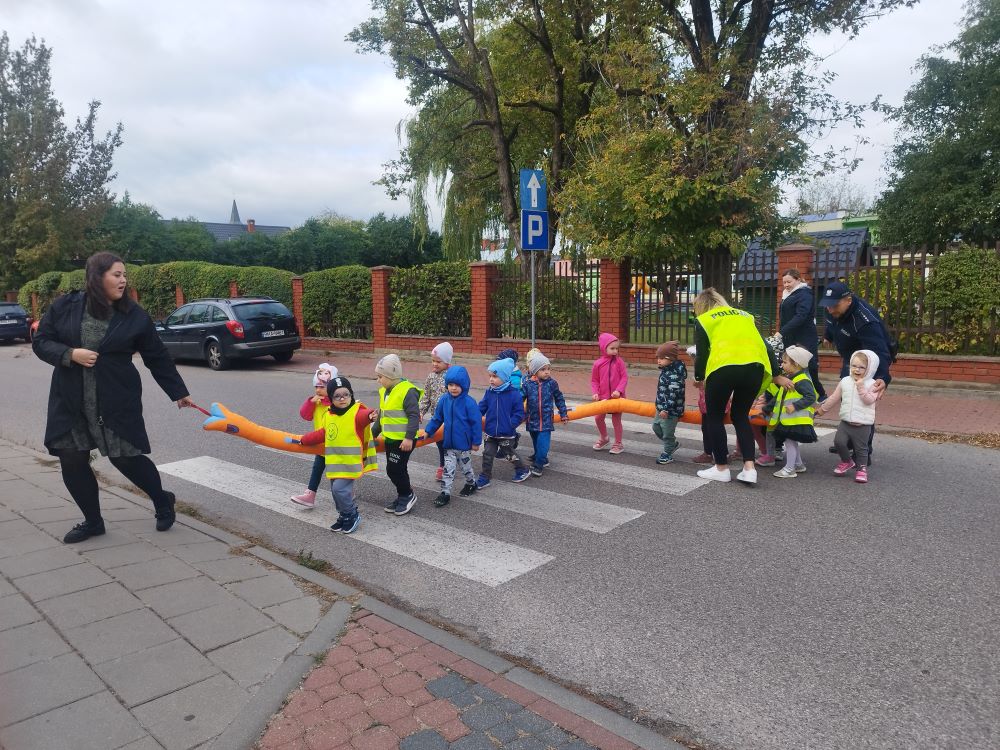 Przedszkolaki na przejściu dla pieszych. Dzieci prowadzi kobieta